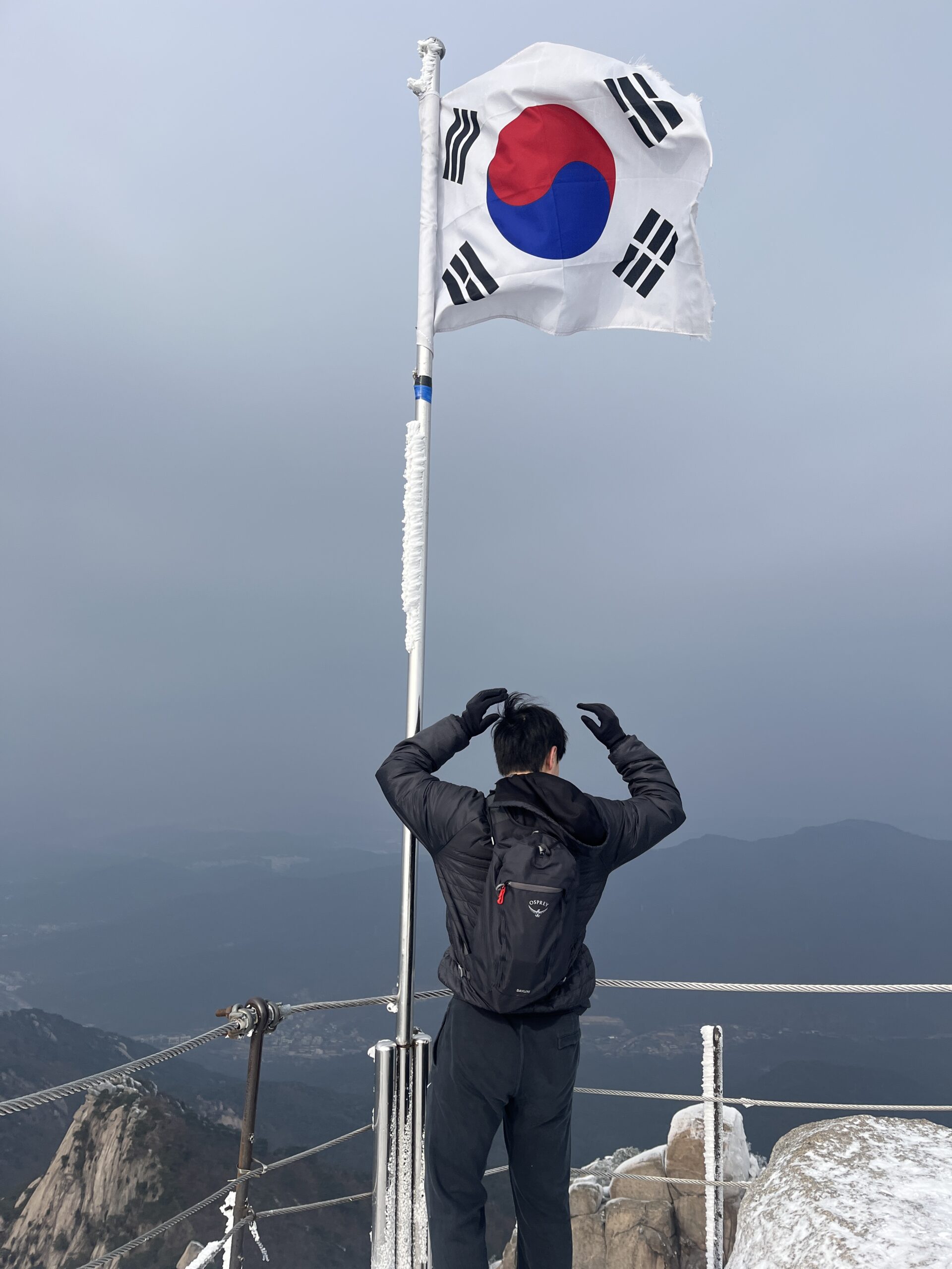 A Korean local traveler at Bukhansan summit with the Korean flag