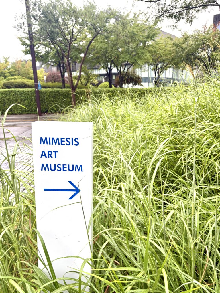  Curved white gallery entrance at Mimesis Art Museum during an exhibition
