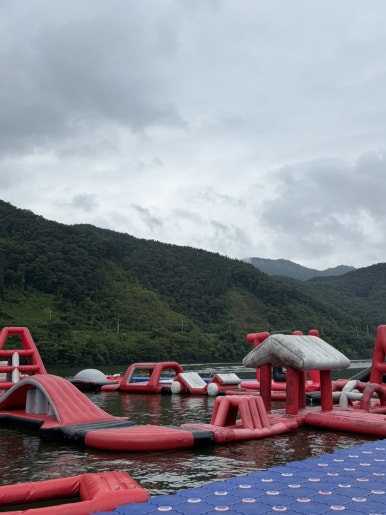 Floating water-park obstacles with forested mountains behind Ten Park